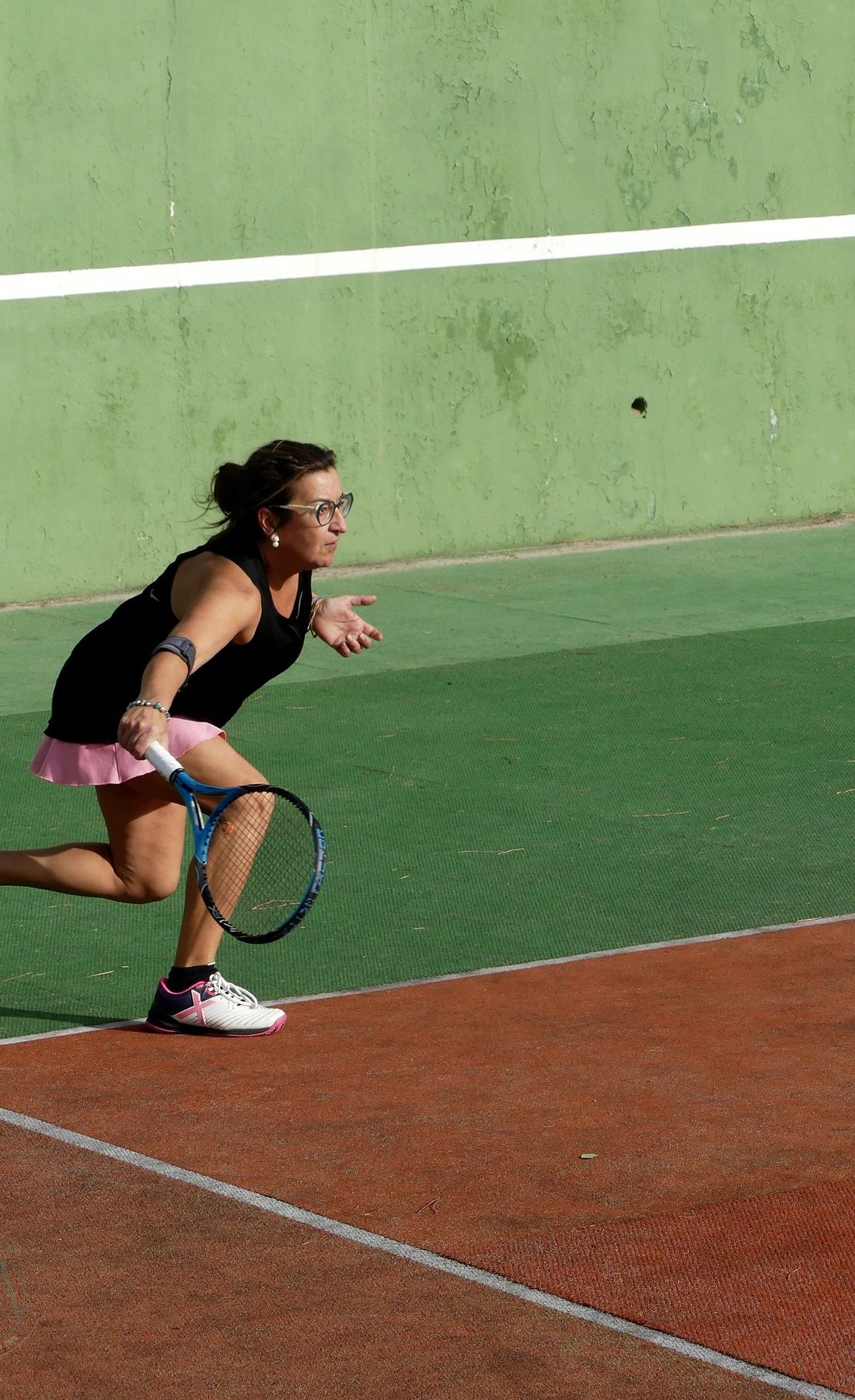 Una socia jugant a tennis en una de les tres pistes del club